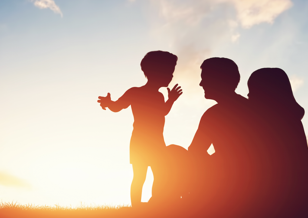 parents with their child in the sunset