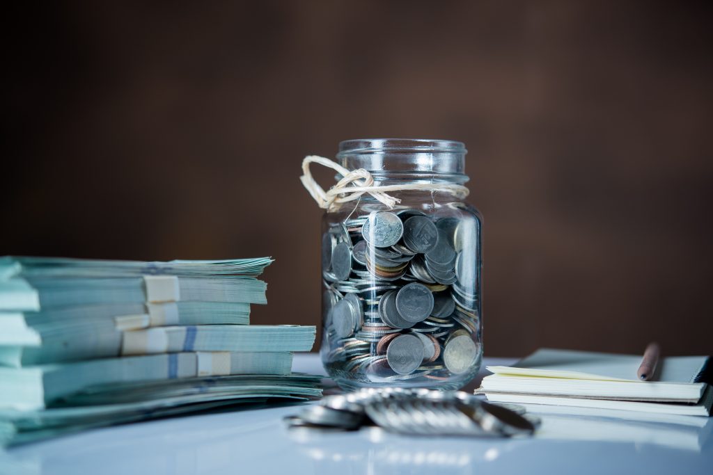 bottles cash with coins saving money concept scaled